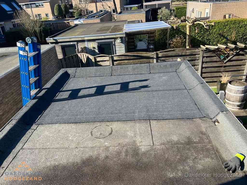 Dakdekker legt onderlaag op plat dak met houten constructie in Hoogezand