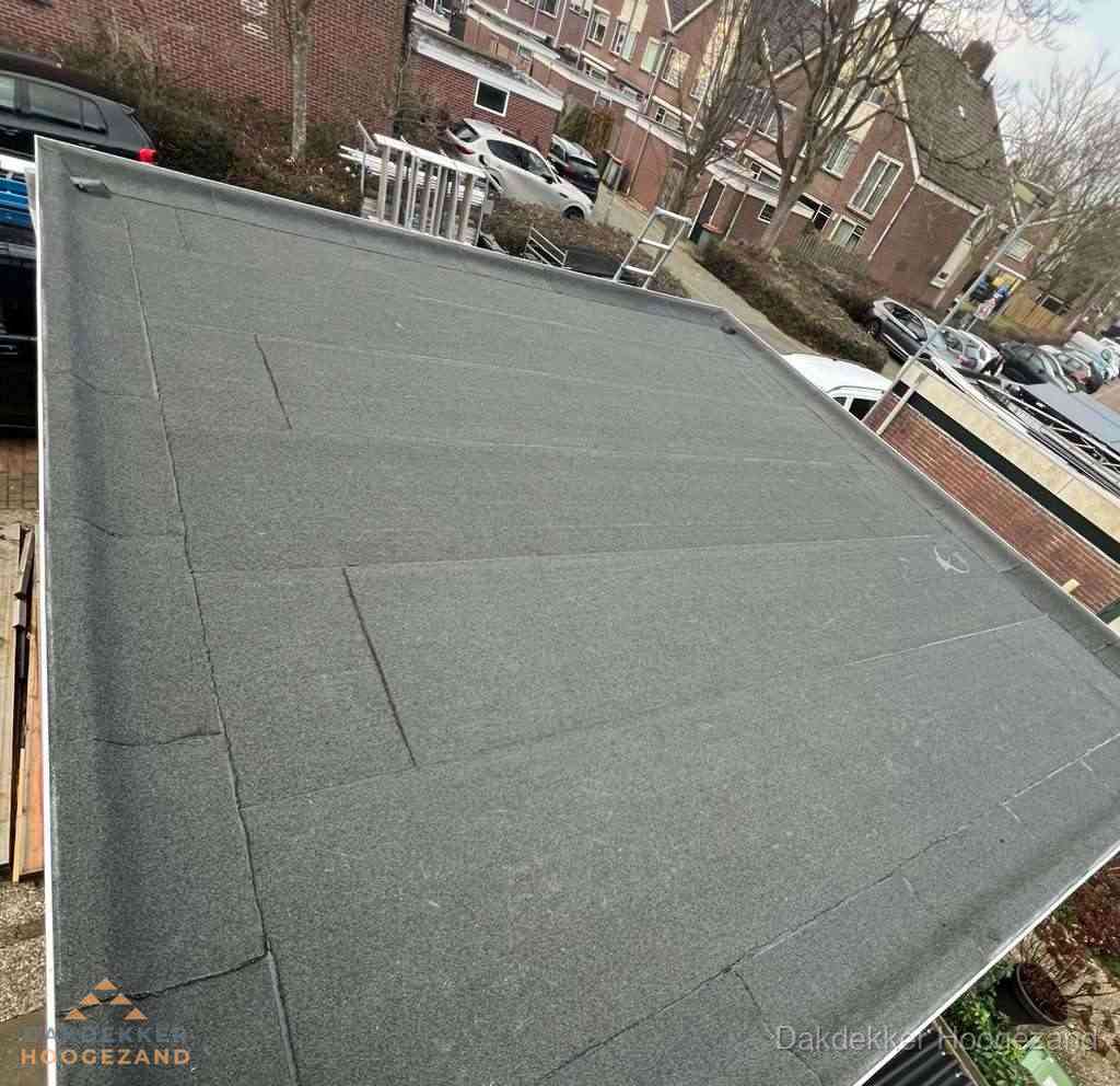 Nieuwe bitumen dakbedekking op plat dak van garage in Hoogezand