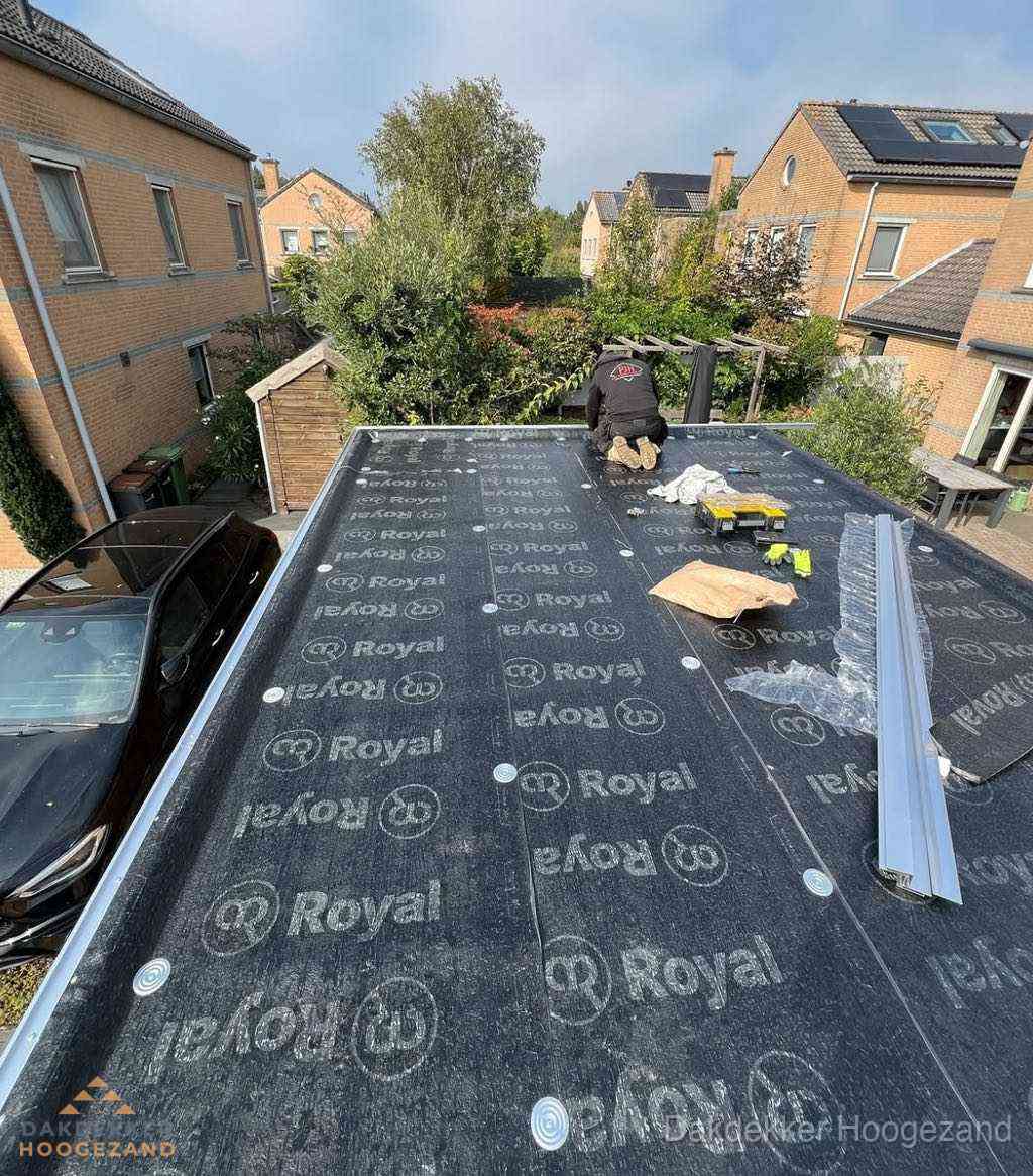 Dakdekker aan het werk op plat dak renovatie in Hoogezand