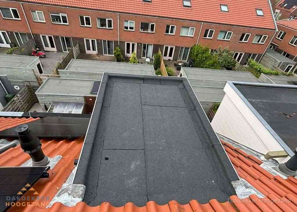 Plat dak met bitumen bedekking naast dakkapel in Hoogezand