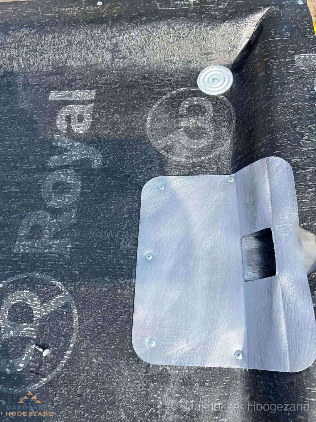 Dakdoorvoer met metalen afvoerplaat op bitumen dak in Hoogezand