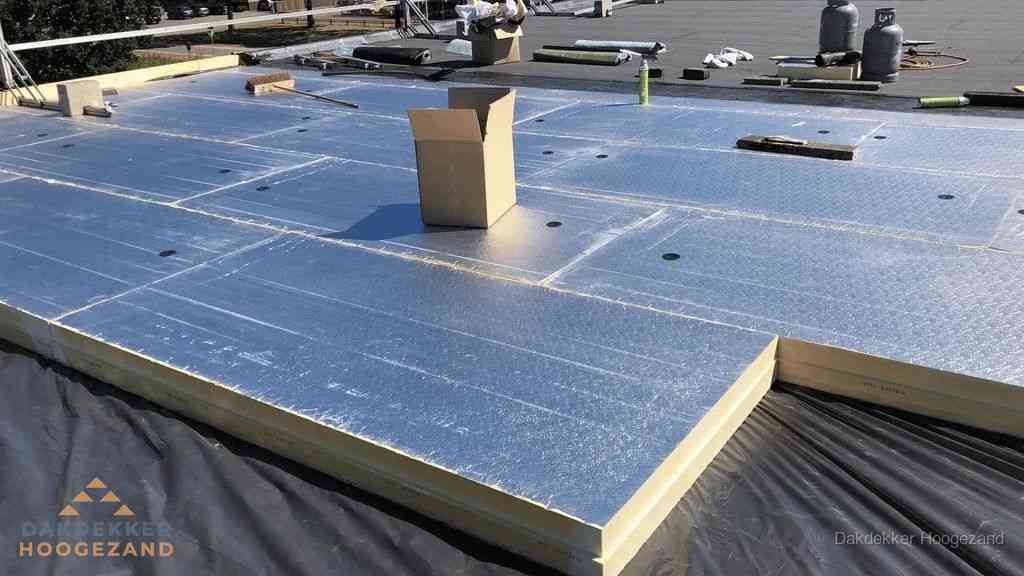 PIR isolatieplaten worden gelegd op plat dak voor dakisolatie in Hoogezand