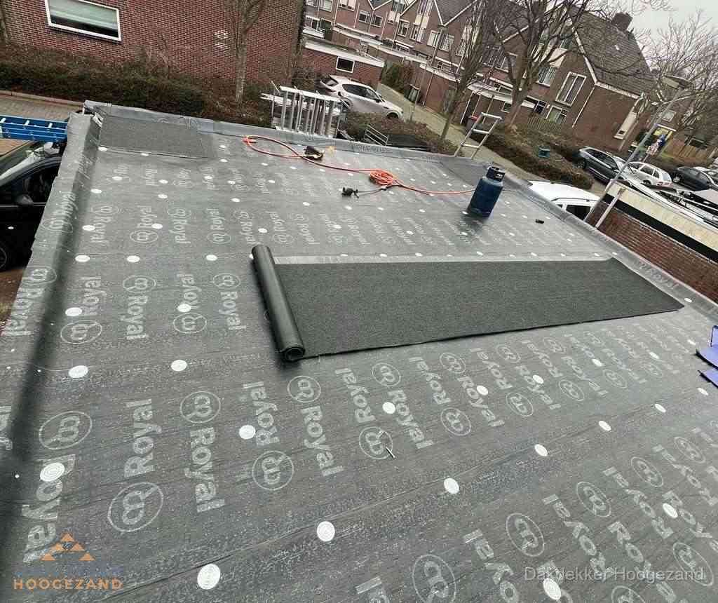 Dakdekker aan het werk met gasbrander op plat bitumen dak in Hoogezand