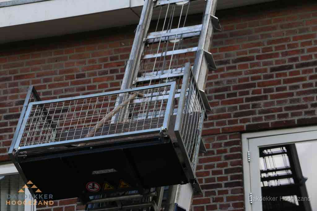 Ladderlift met dakpannen voor dakpan reparatie in Hoogezand