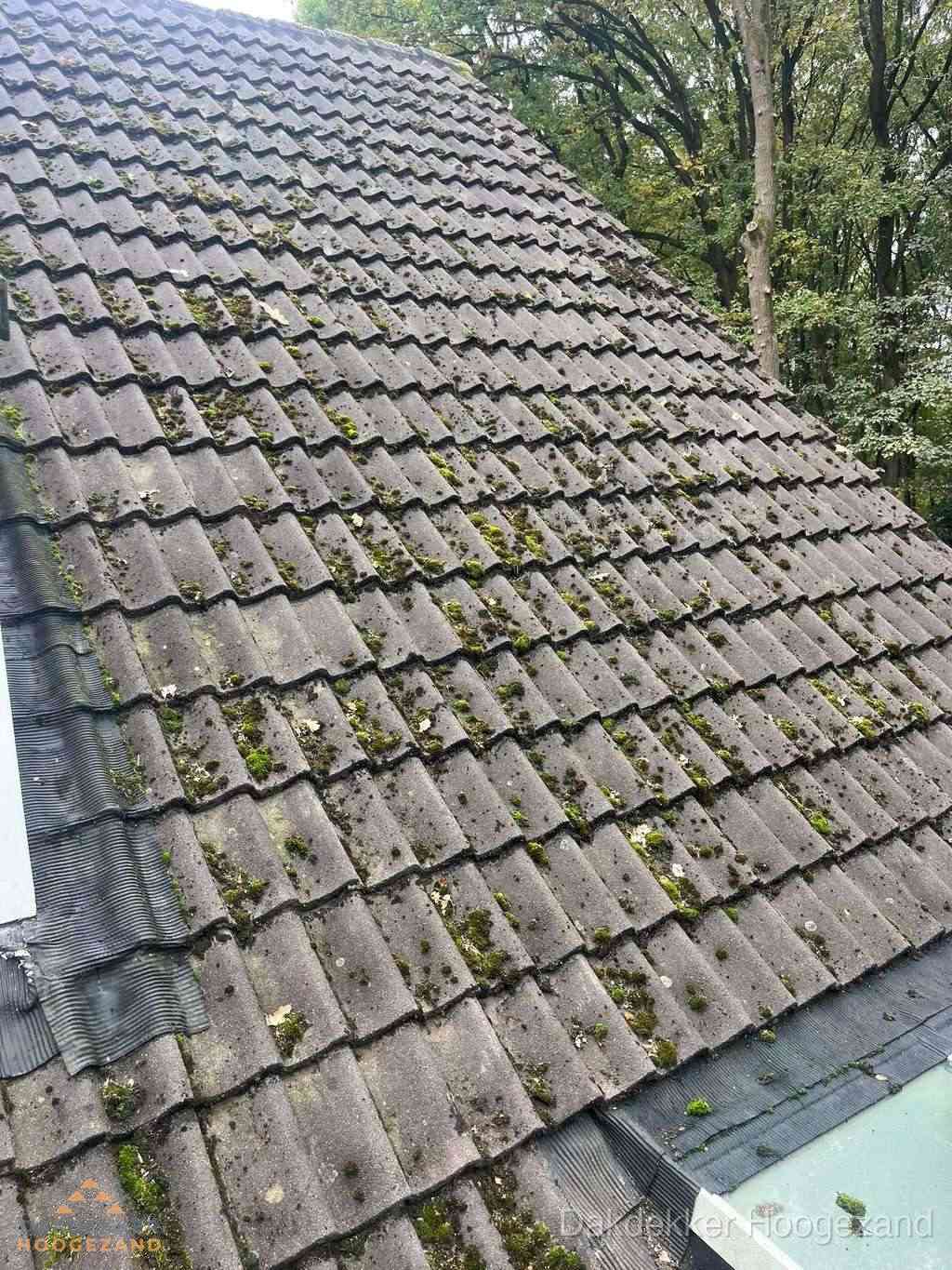 Verweerd pannendak met mosgroei dat renovatie nodig heeft in Hoogezand